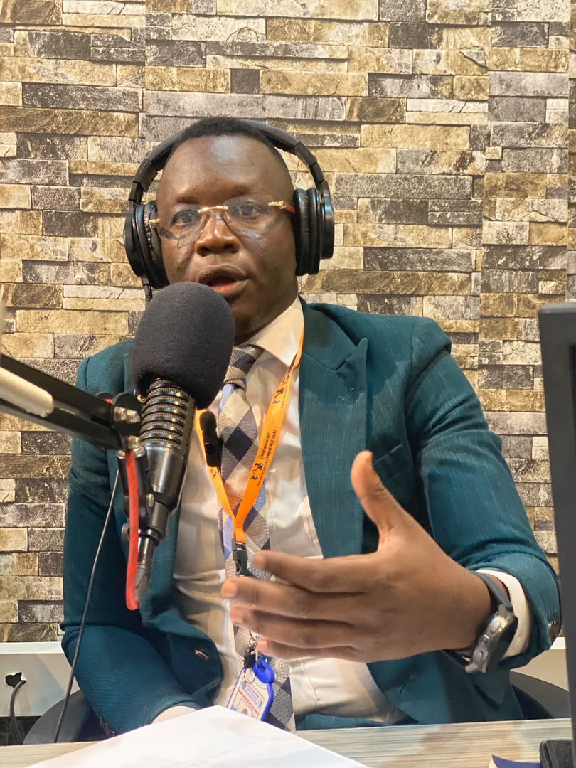 Advocate Emmanuel Sumagule Benaih Swaka speaking on air, wearing headphones.