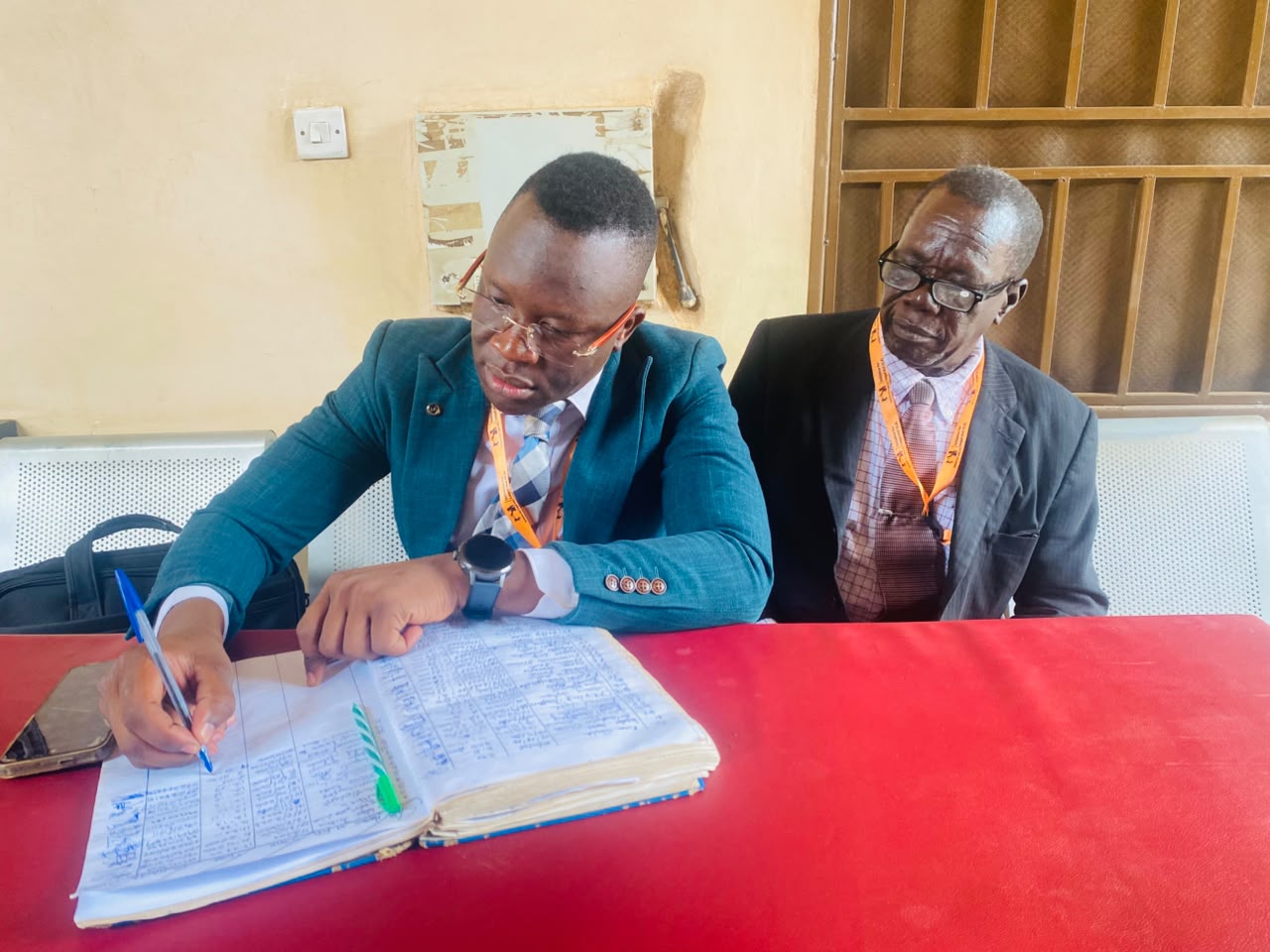 Two ILA representatives seated at a table, one writing in a notebook.